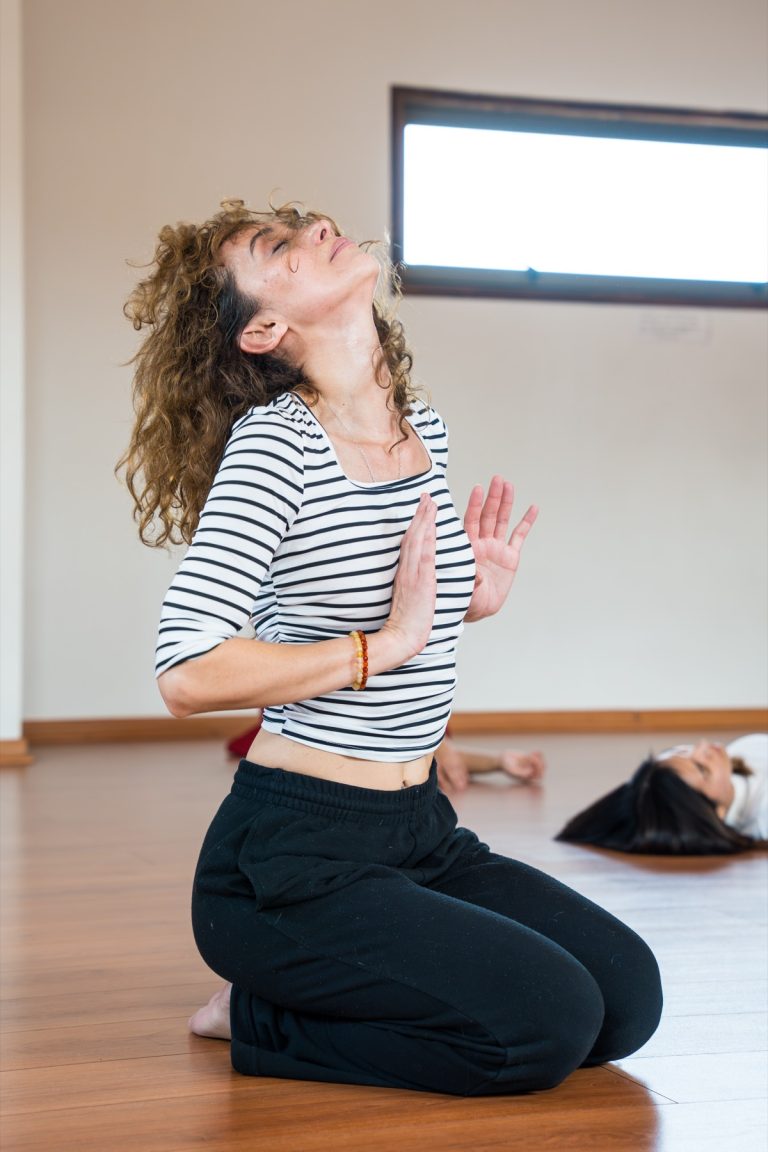 Alumna de rodillas con la cabeza hacia atrás, en una vivencia de danza
