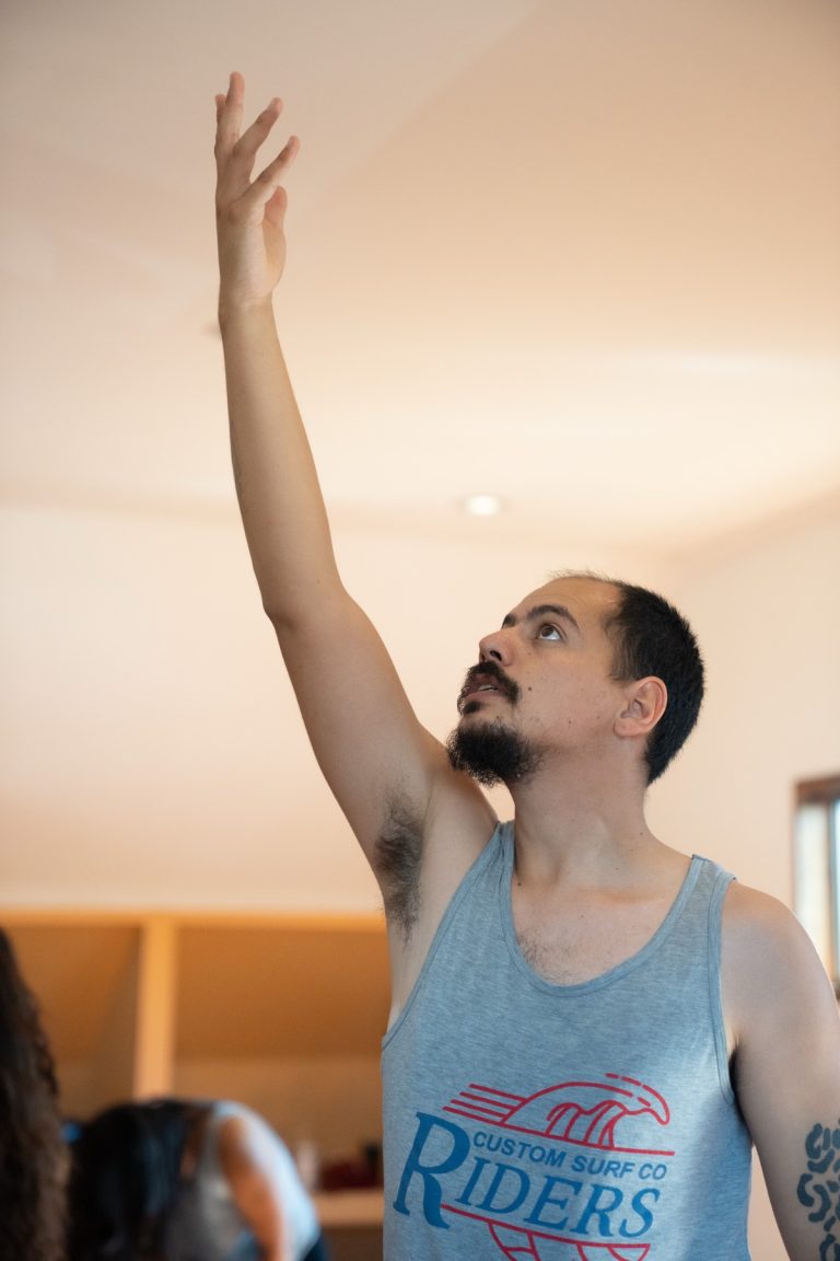 Alumno con el brazo extendido hacia el cielo
